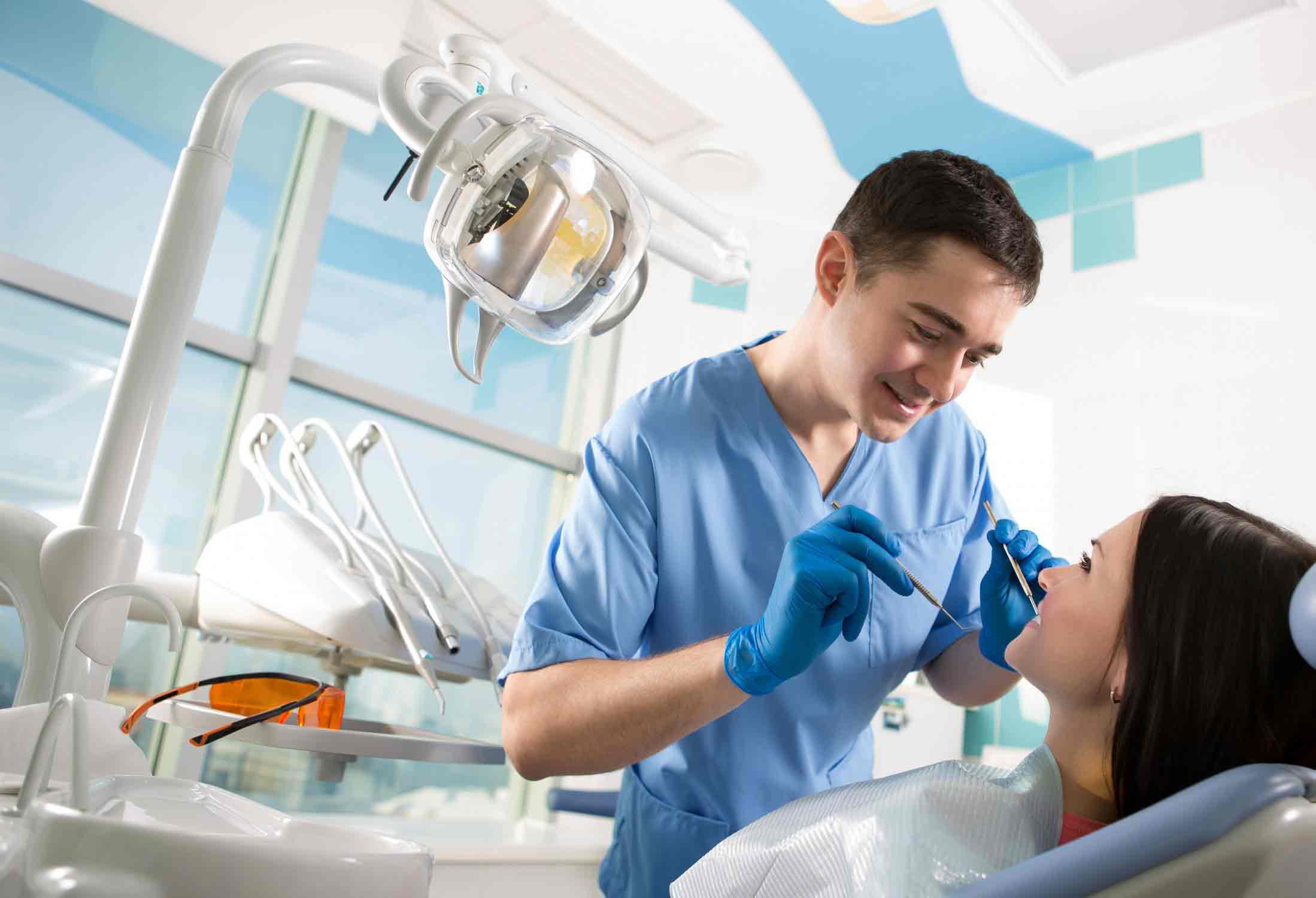 young doctor dentist examines the mouth of the patient