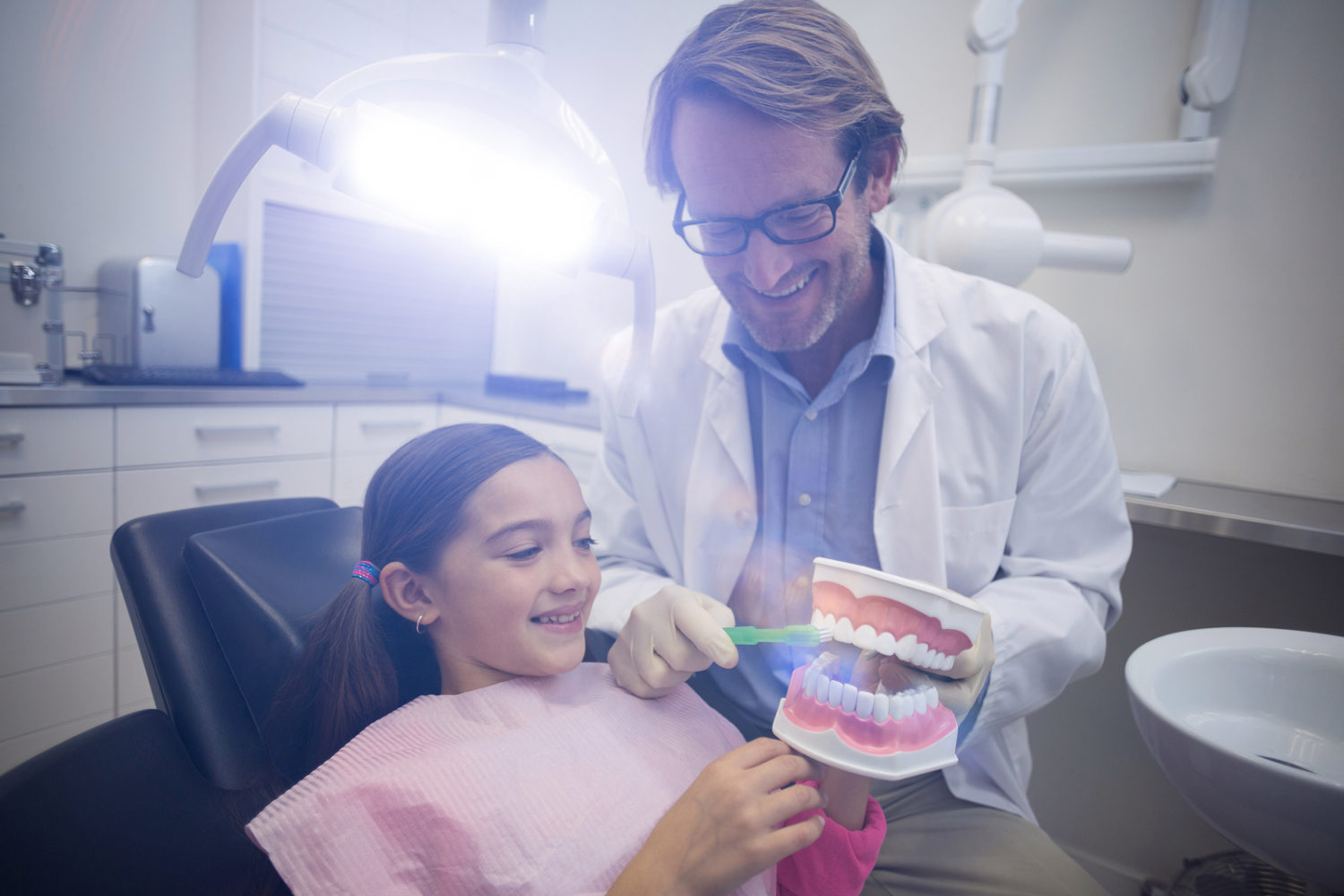 Dentist showing a kid proper brushing techniques